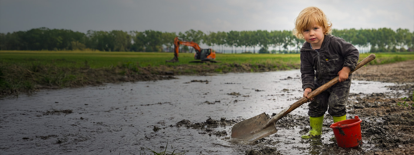 Foto van van kind met schep in de bagger